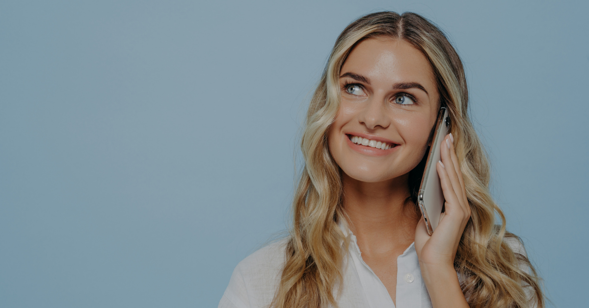 Smilende kvinne som snakker i telefonen