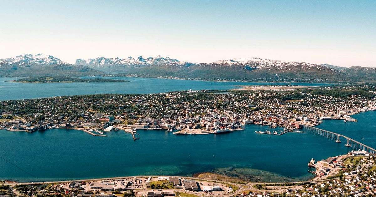 Tromsø sett fra lufta med Tromsøya, brua og snødekte fjell